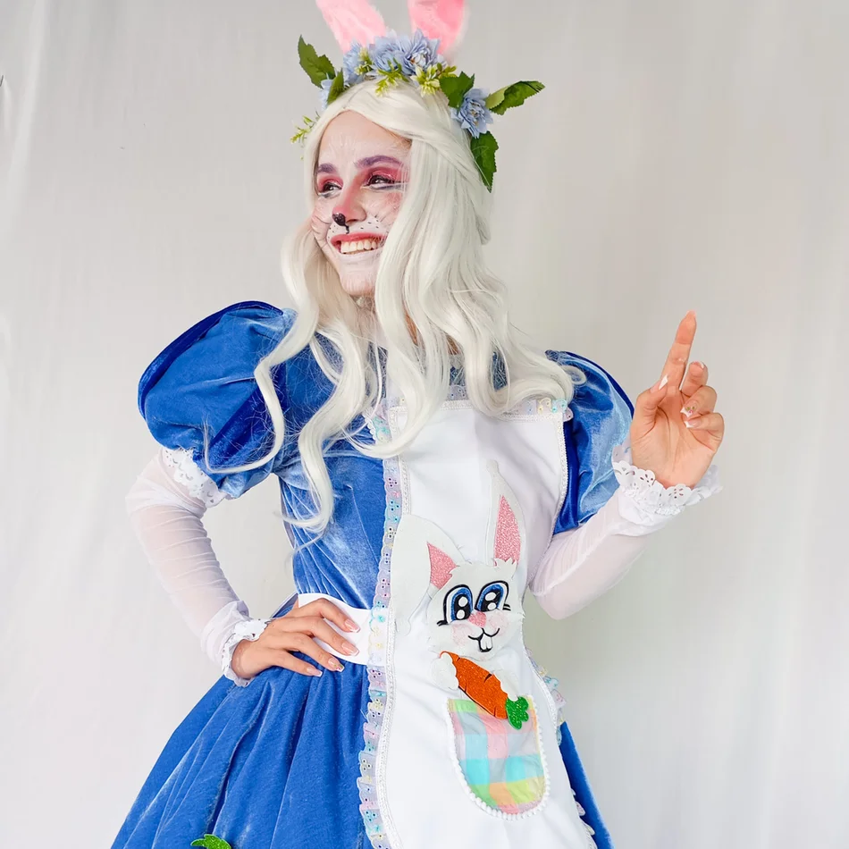 Coelhete Azul Personagem Vivo posando ao lado da mesa do bolo em aniversário infantil